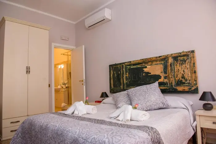 Camera con bagno privato: letto, armadio e la porta del bagno in camera