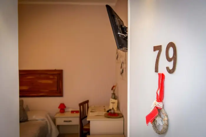 La porta della camera 79 con il nastro rosso, e dentro il letto