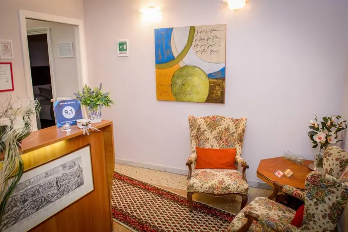 L'accoglienza: il banco con le mappe di Roma, le poltrone e i quadri